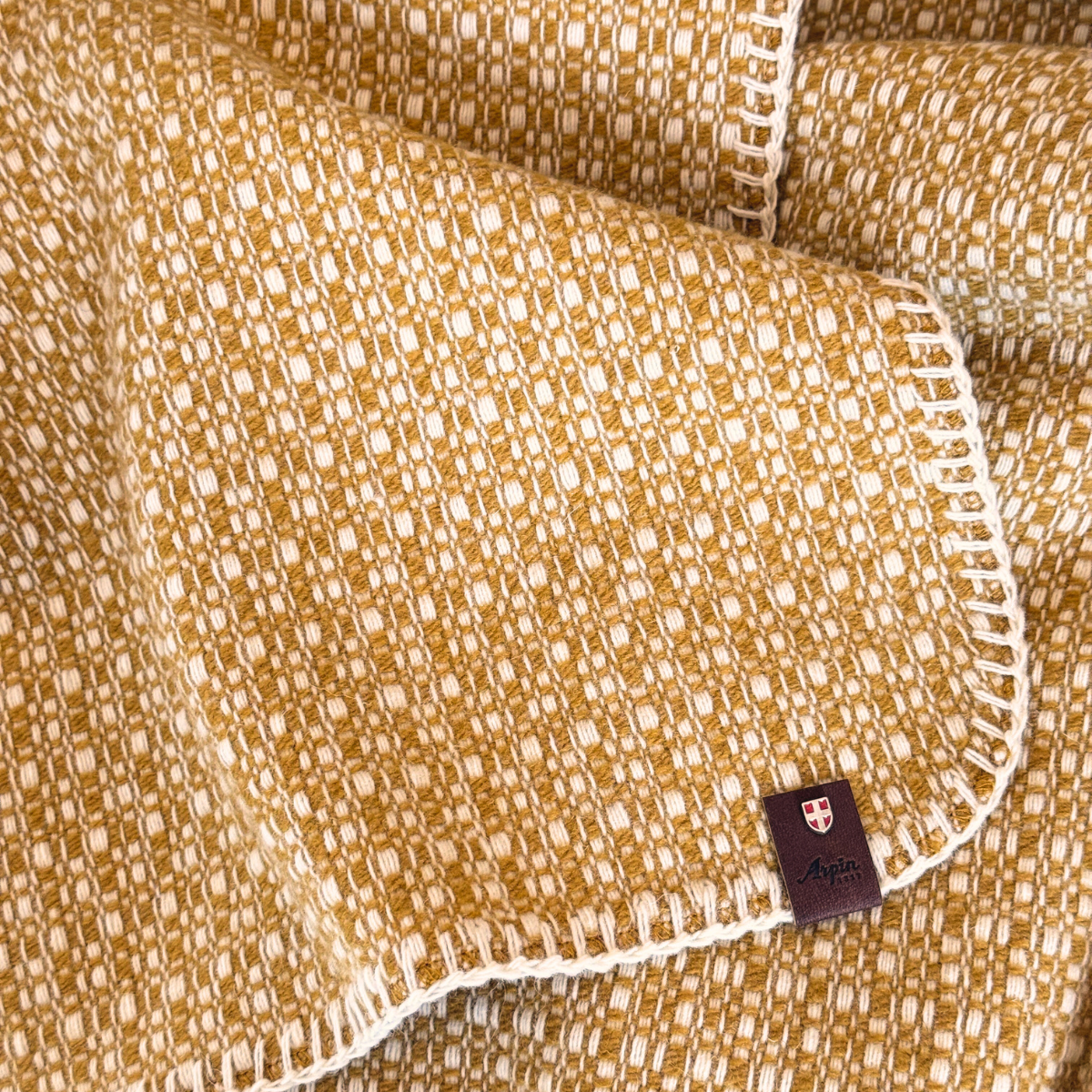 Détails du tissage du plaid en laine ocre Ancolie